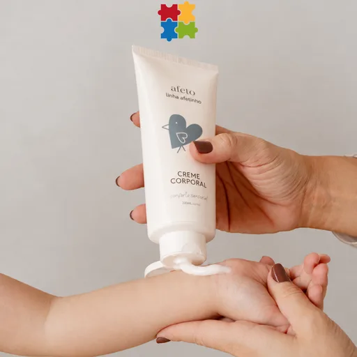 Creme Corporal Conforto Sensorial da linha Afetinho sendo aplicado na mão de uma criança